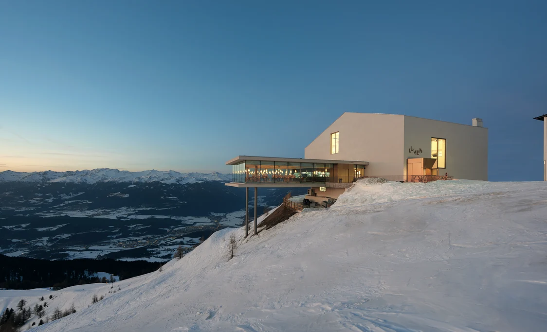 Illuminated street at dusk with modern streetlights and buildings in the background, Zumtobel