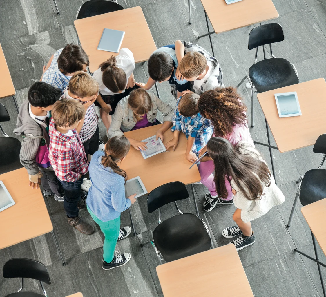Basisschoolklas met kinderen die samen rond één bureau zitten