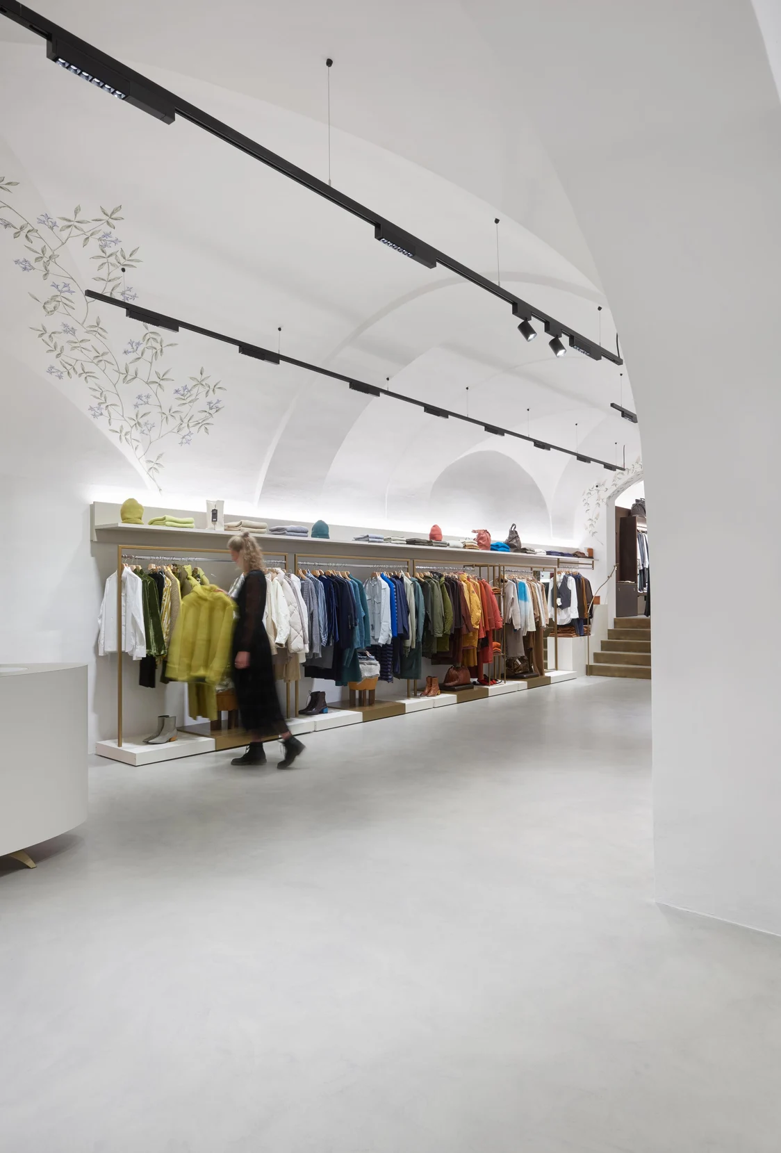  Das SUPERSYSTEM INTEGRAL beleuchtet eine moderne Boutique mit gleichmäßigem, blendfreiem Licht, während Kleidung präsentiert wird.