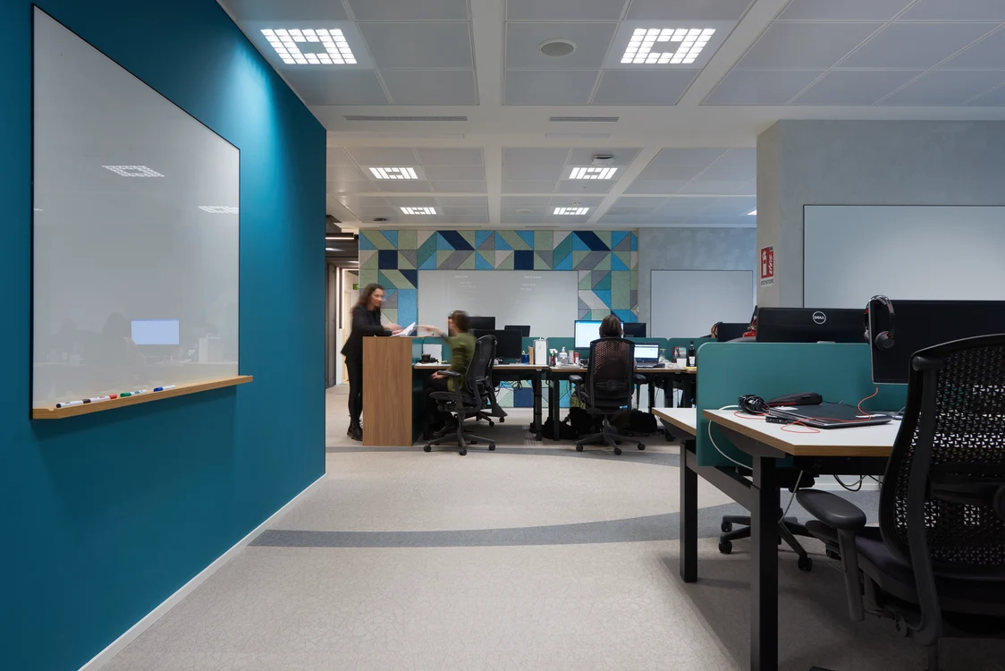 MIREL evolution beleuchtet gleichmäßig einen modernen Konferenzraum mit großem Holztisch und schwarzen Stühlen.