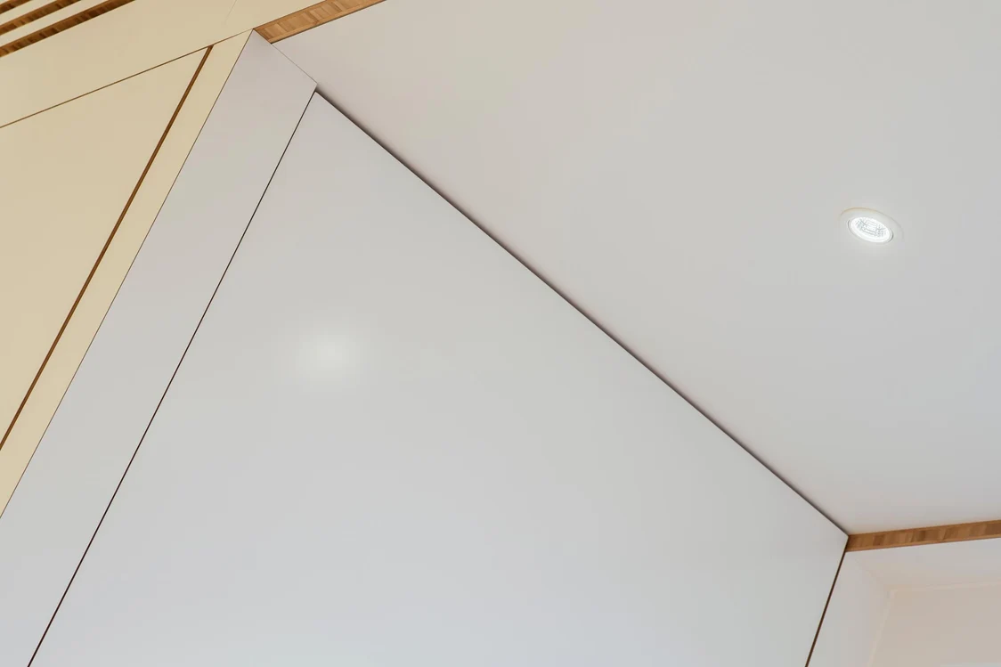 DIAMO LED spotlight evenly illuminates a modern ceiling with wooden accents and provides clearly defined light in a minimalist interior.