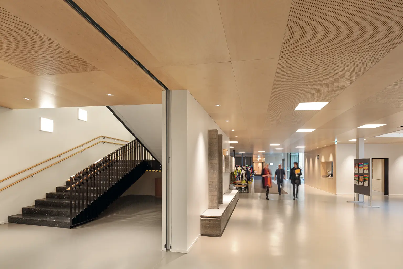 Korridor mit Treppe in der Herrenried-Grundschule, zeigt Menschen und die neue Beleuchtung