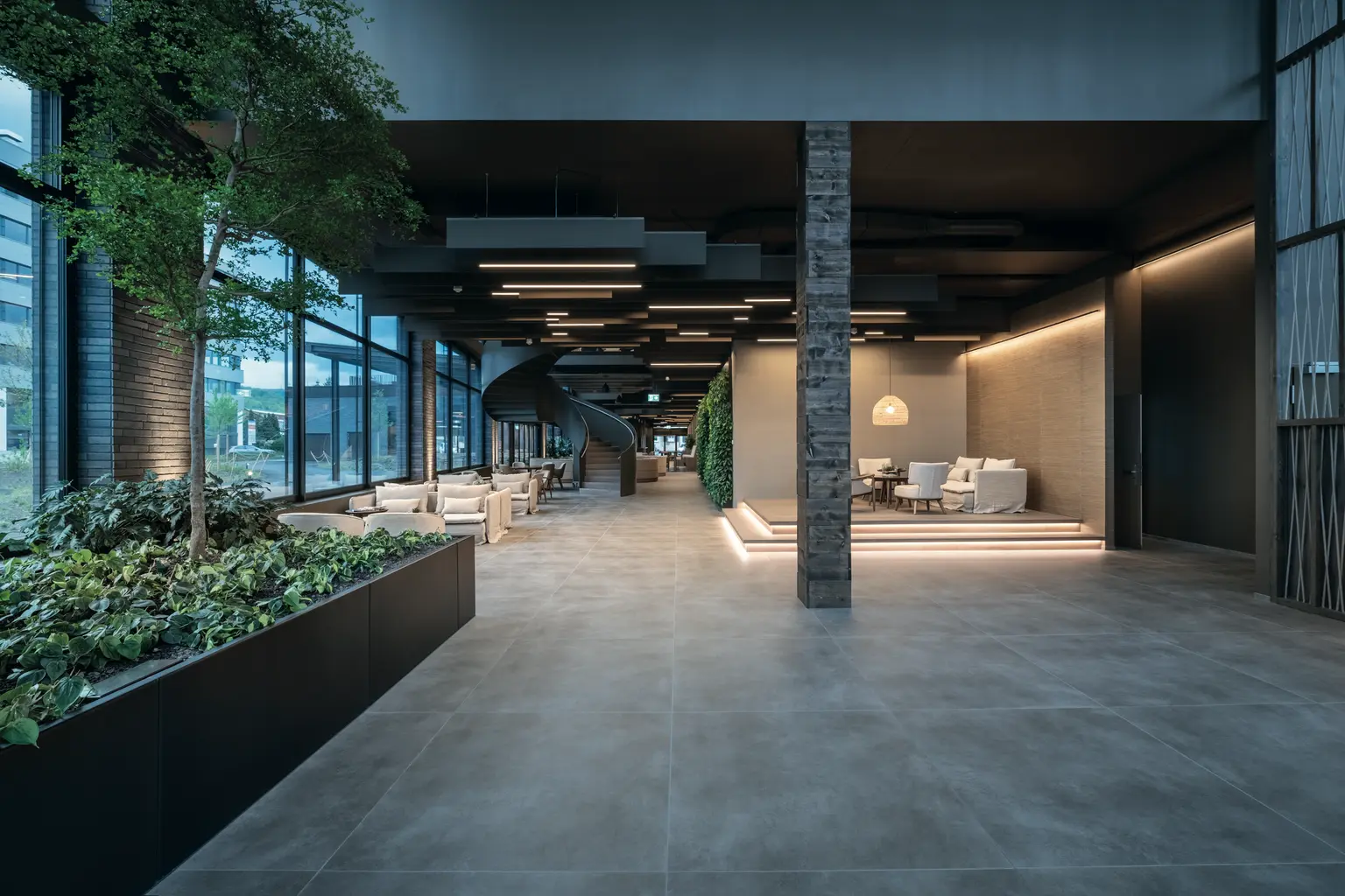 Hall d'entrée de la Haus der Wirtschaft avec des jardinières sur la gauche et des sièges éclairés