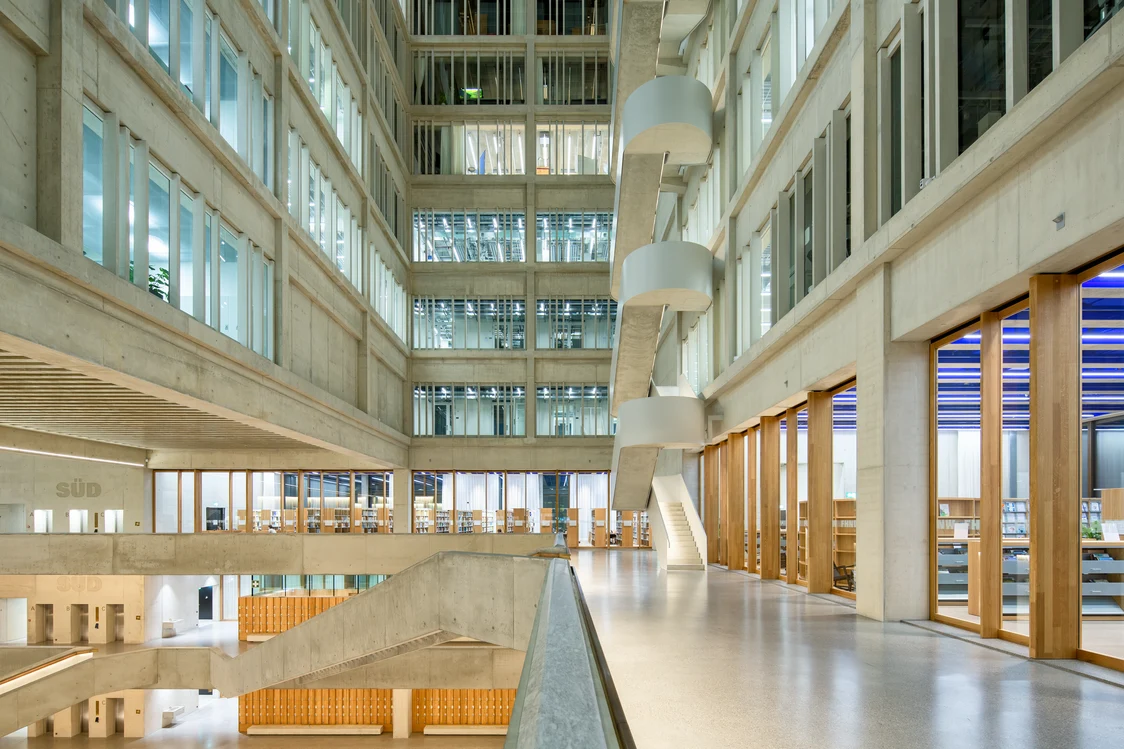Innenansicht des FHNW Campus mit offenem Atrium, Sichtbetonfassaden und umlaufenden Glasfronten. Die durchgängige Lichtlösung mit FREELINE-Leuchten sorgt für klare Struktur und eine ruhige Atmosphäre.