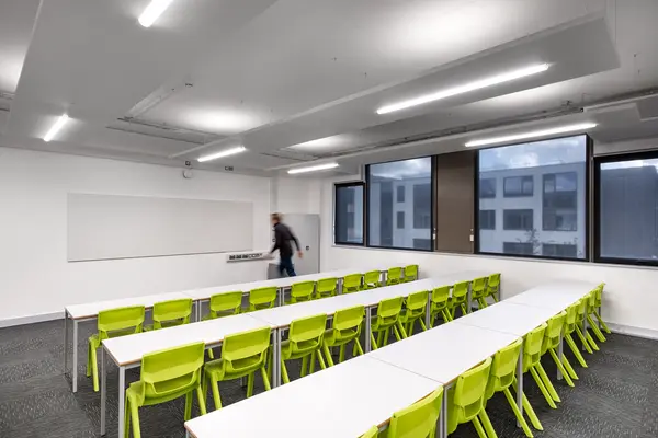 Secondary school classroom with whiteboard and seated rows of desks
