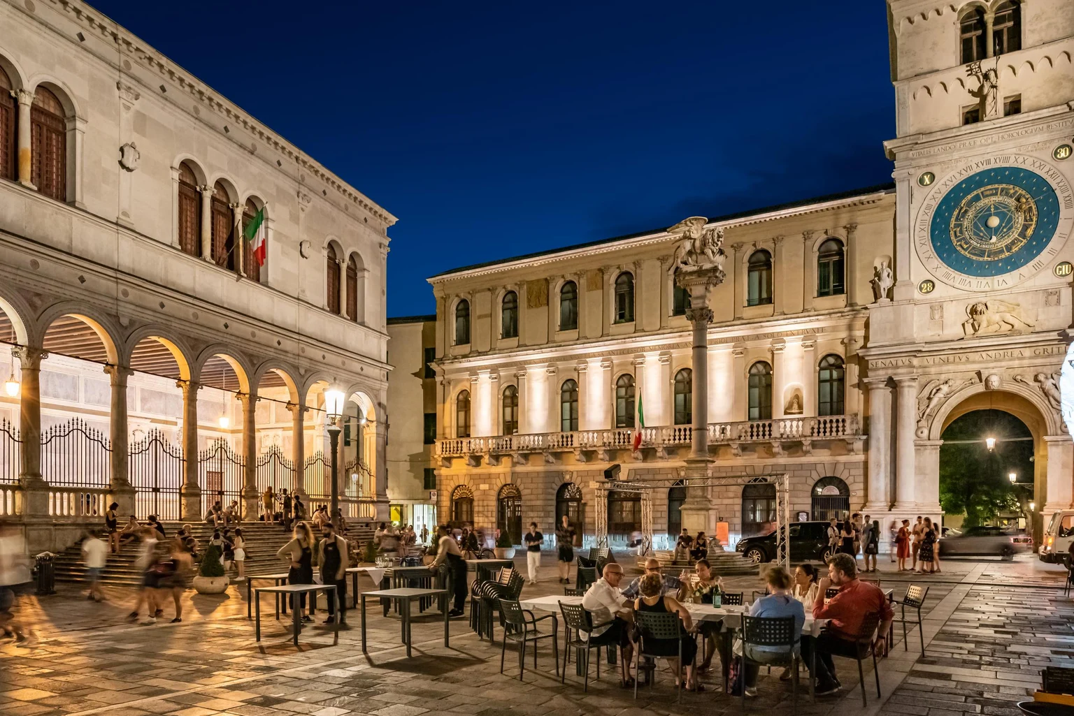 Palazzo Orologio Piazza la nuit avec des gens qui profitent de l'espace extérieur