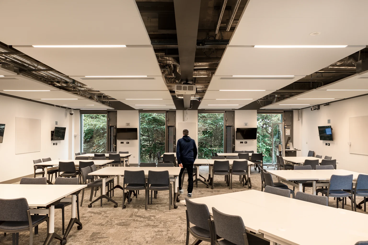 Een universiteitslokaal met meerdere bureaus, opgesteld voor een interactieve discussie en groepswerk