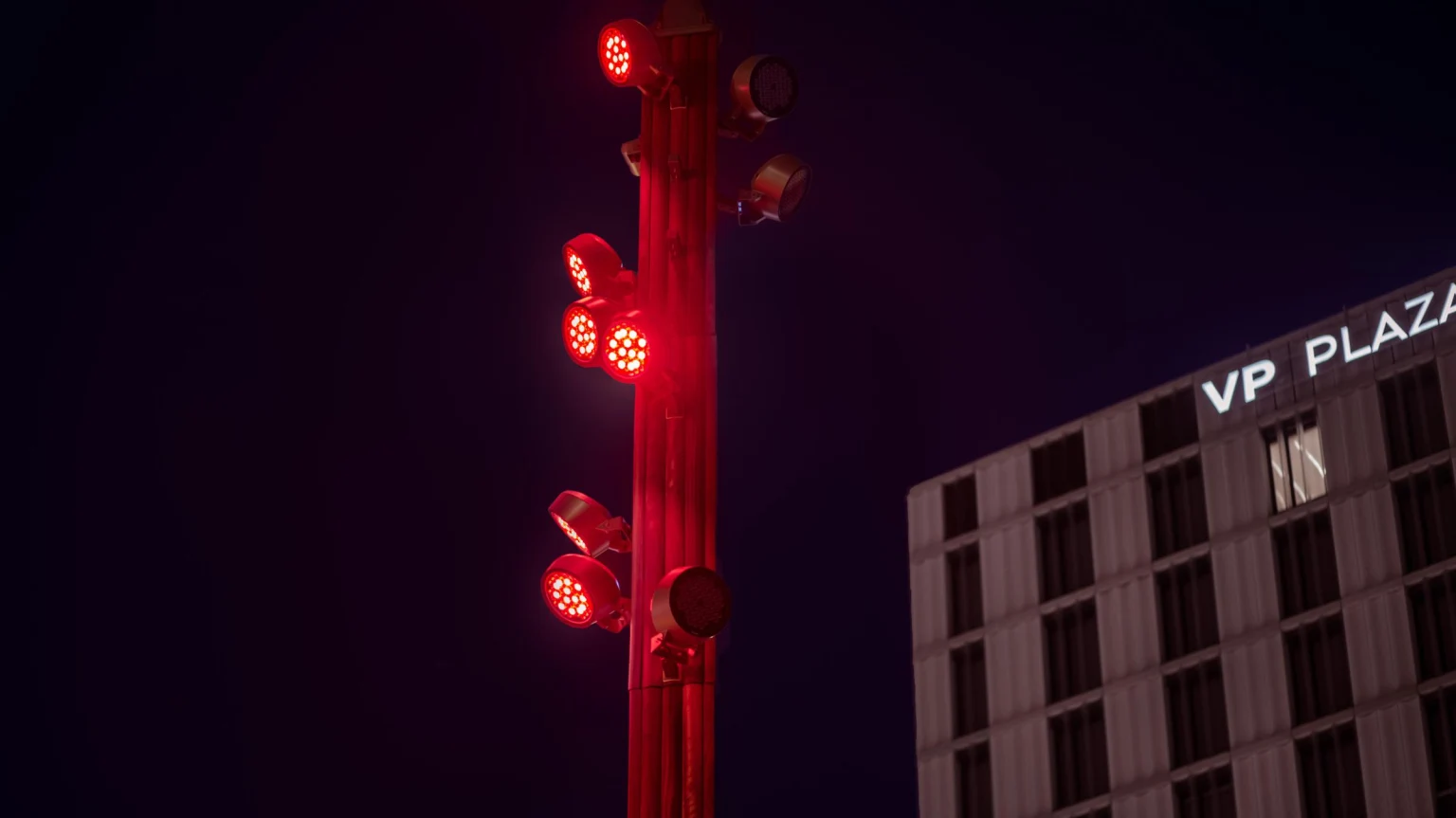 Rode ledspots op de mast zorgen voor dynamische accentverlichting, wat een kleurrijk visueel element toevoegt en de architectuur van de stad benadrukt.