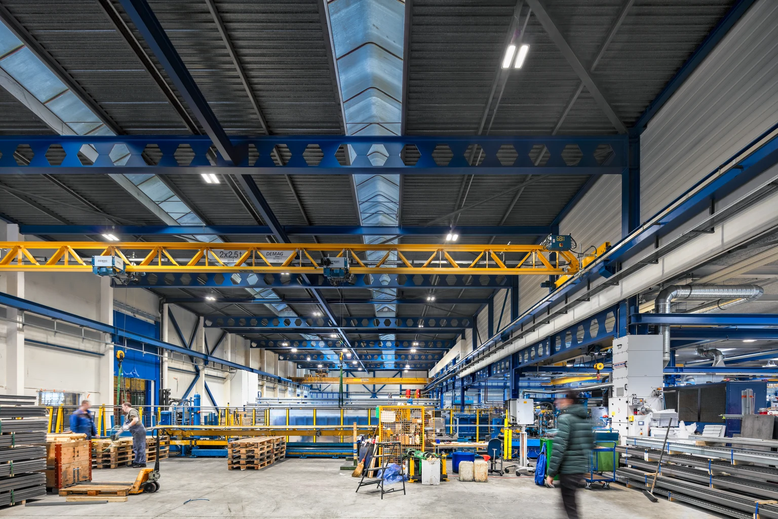 Industrial hall with Zumtobel lighting, yellow crane and shelves, modern factory hall