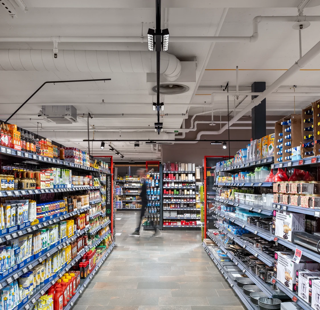 Il sistema di illuminazione SCENO illumina un moderno negozio di alimentari con una luce uniforme.