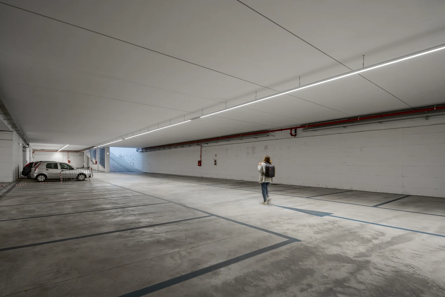 Parkeerplaats van Euronics met twee auto's die al geparkeerd staan en iemand die de parkeerplaats te voet verlaat