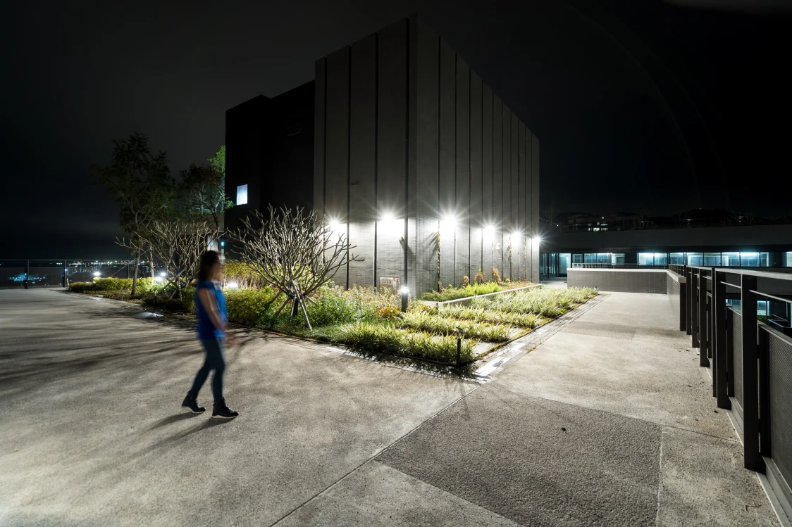 Ein Bürogebäude mit Beleuchtung an der Fassade und im Außenbereich