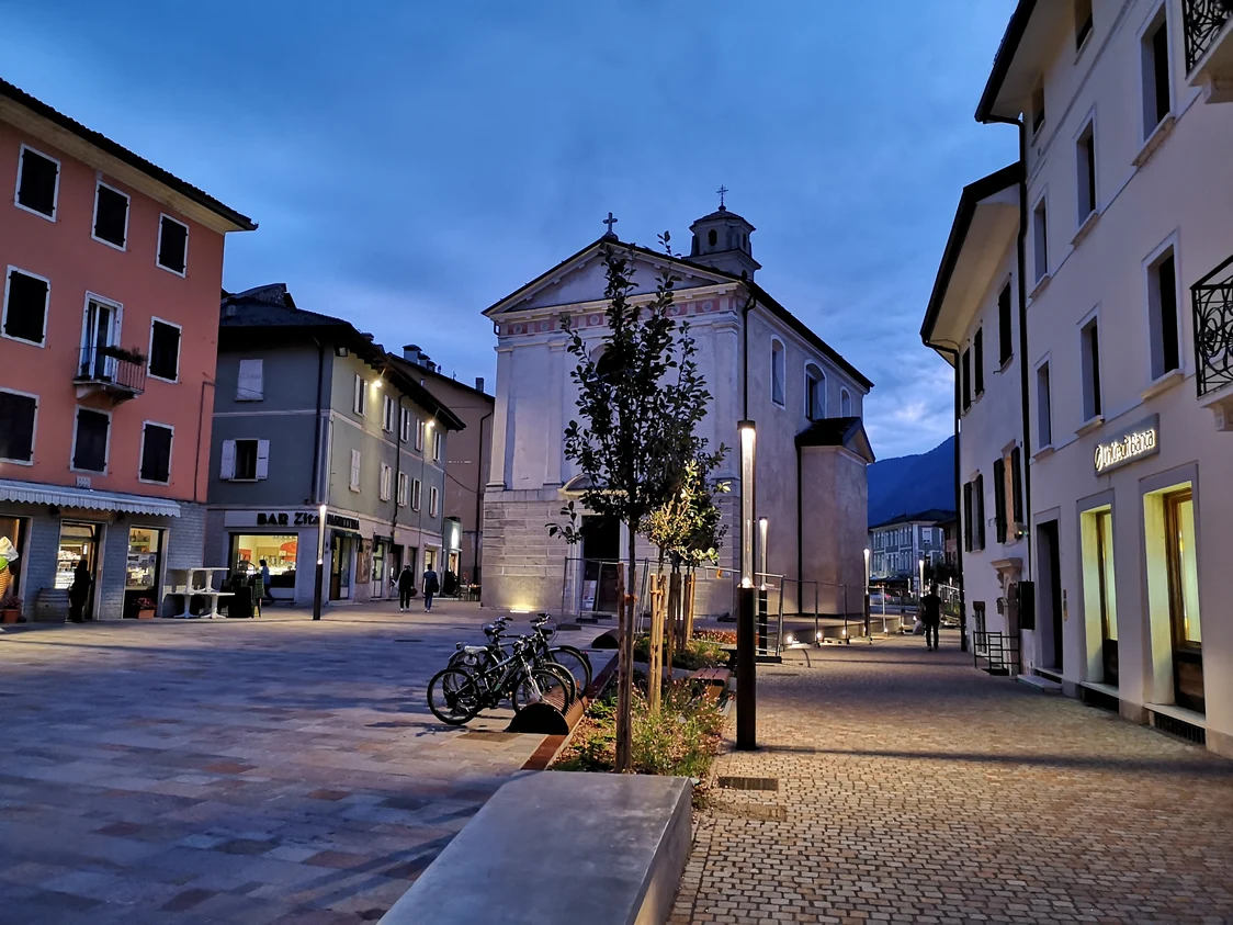 Eine Stadt bei Nacht mit einem historischen Gebäude im Hintergrund.