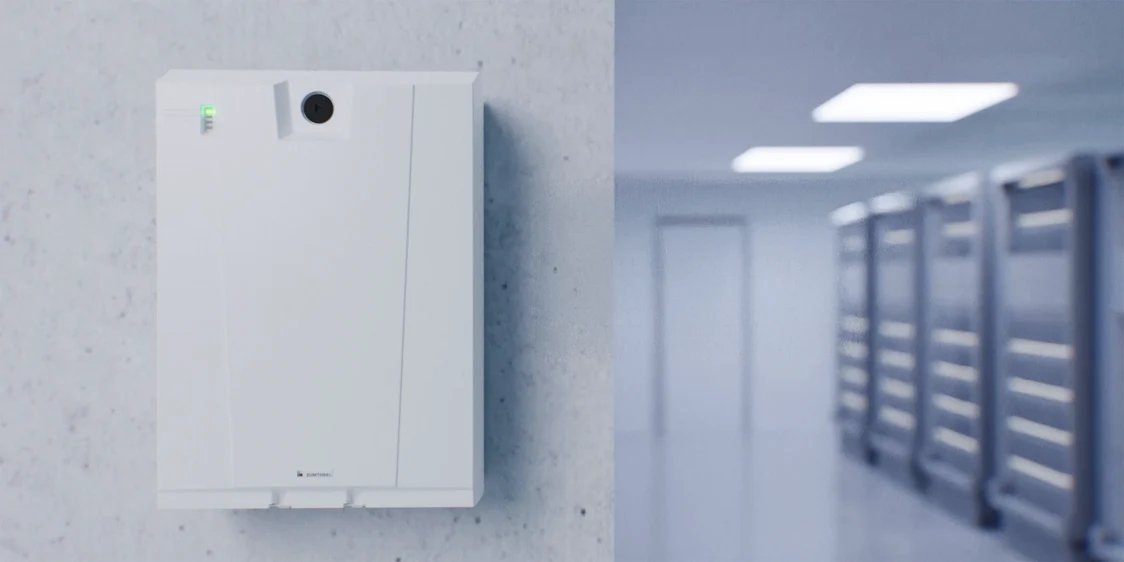  Die ONLITE central nBOX ist an einer Betonwand in einem modernen Korridor montiert, während LED-Lichter den Flur gleichmäßig beleuchten.