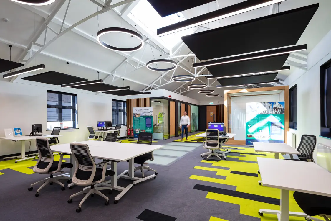 Templemore Library and Enterprise Centre, Tipperary - A man stands in a modern open plan office with clean desks and stylish chairs