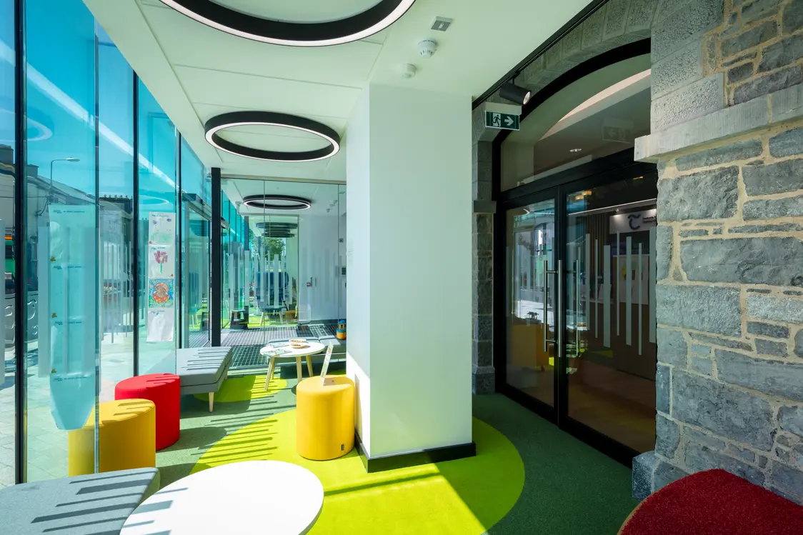 Templemore Library and Enterprise Centre, Tipperary - A modern, bright and airy breakout area featuring stylish brightly coloured stool seating, small contemporary tables with abundant natural light and a clean design.
