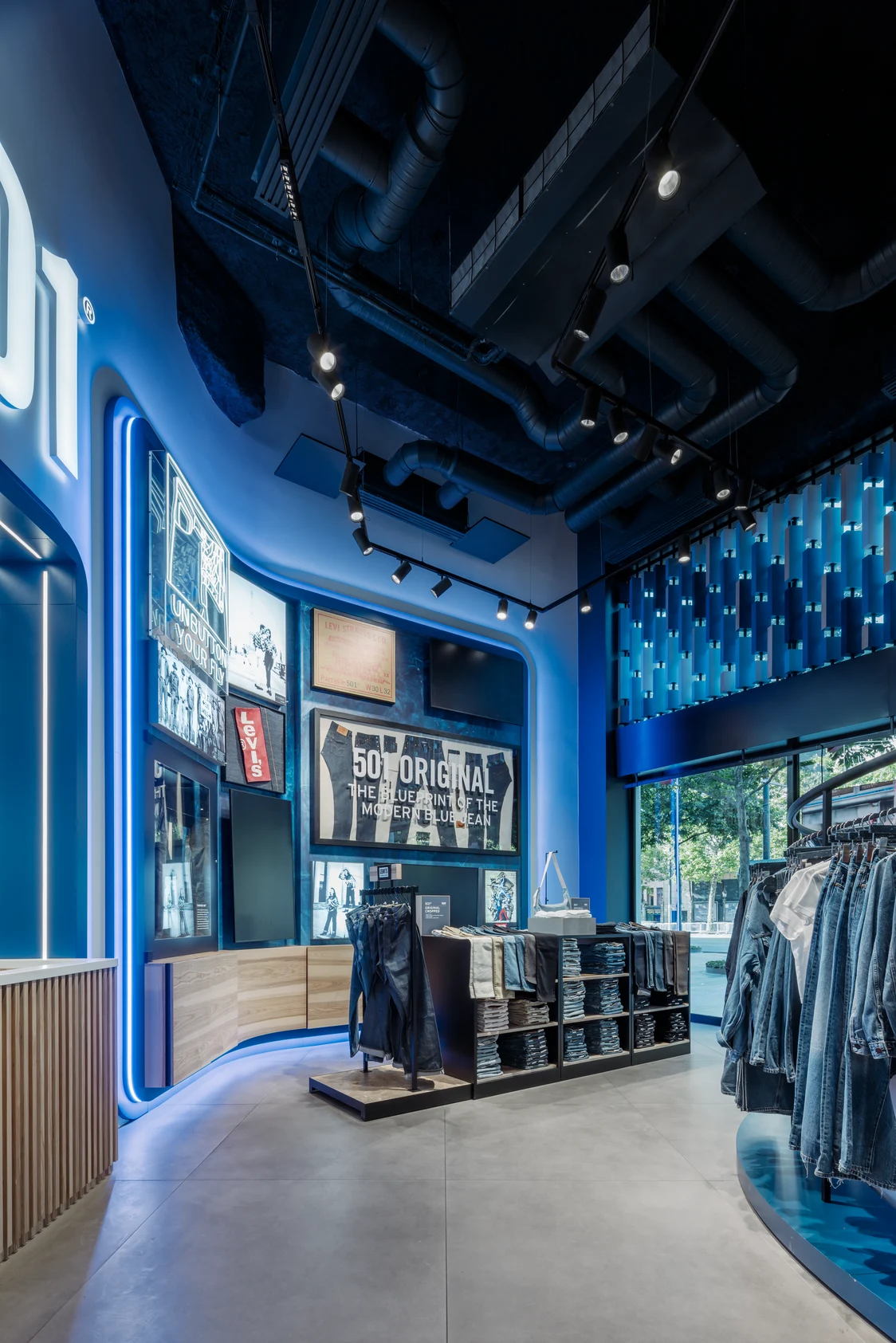 Levi Strauss flagship store with dynamic Zumtobel lighting, blue LED accents, and modern denim presentation in retail design.
