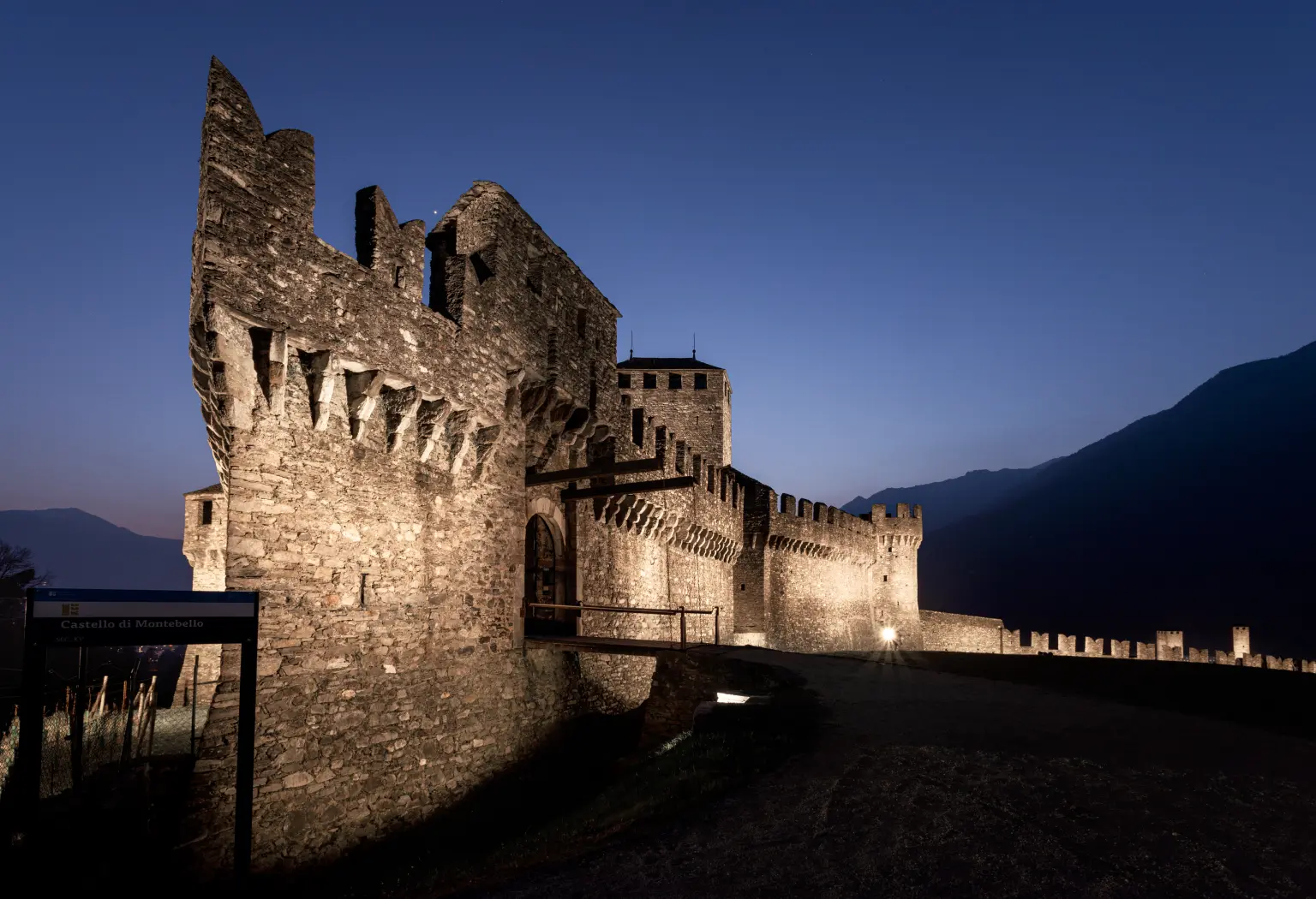 Une forteresse de la Fortezza Bellinzona avec éclairage extérieur des remparts et des douves, ainsi que de la porte du château