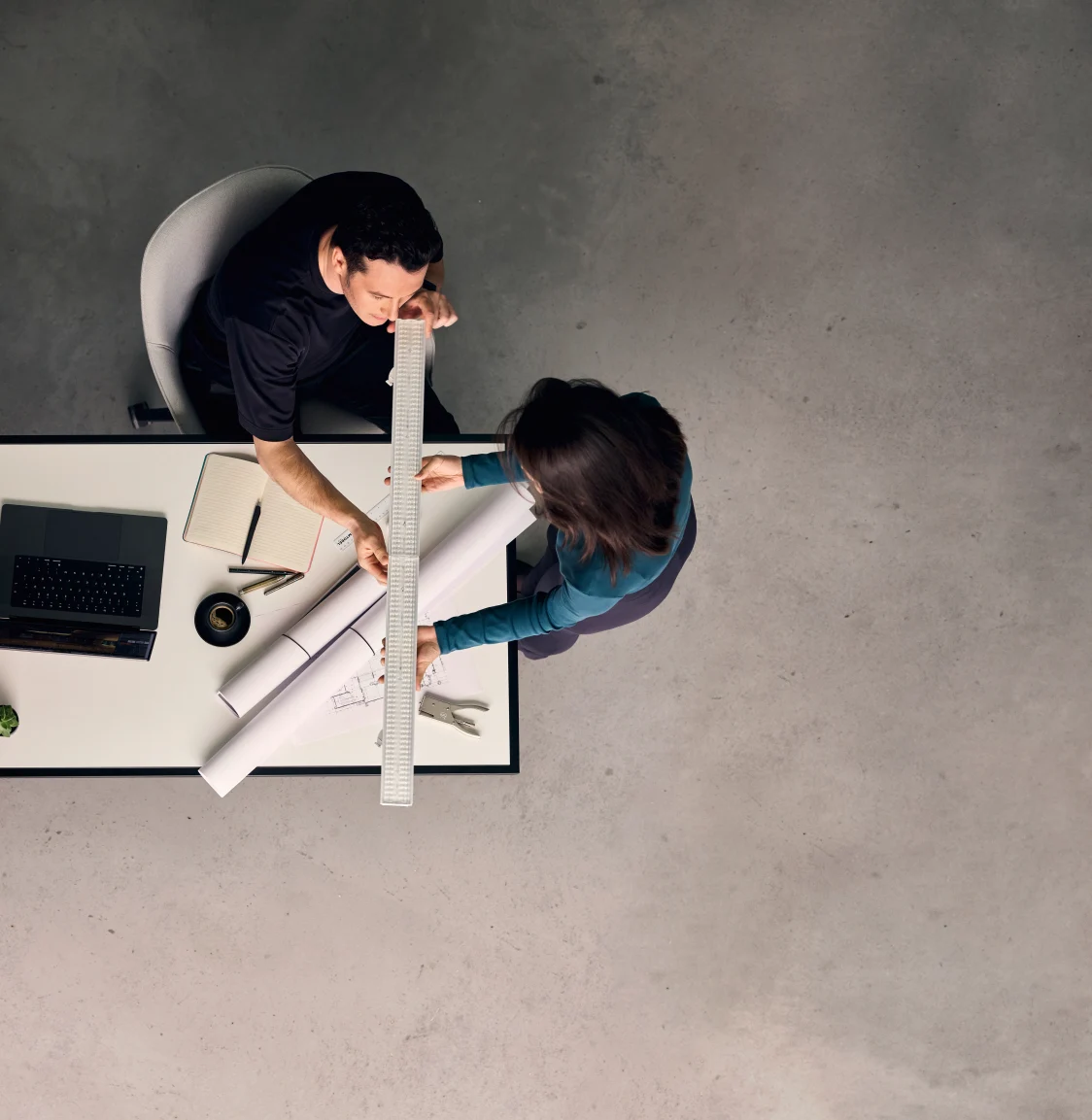 Deux personnes assises et travaillant à un bureau en vue aérienne.