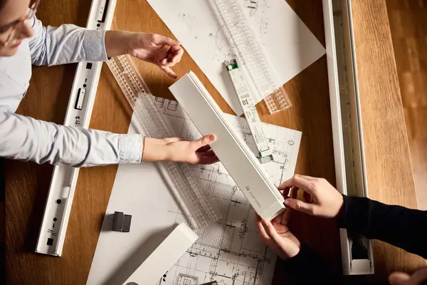 Accessories are visible, spread out on a table, with hands working on them. 