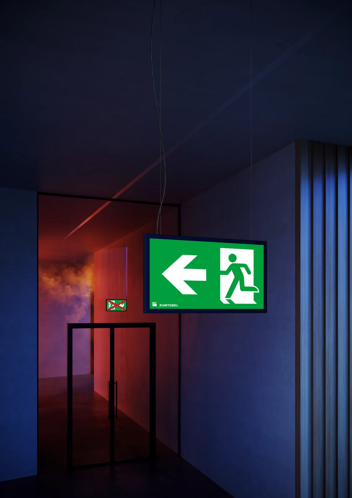 Gros plan sur deux luminaires de signalisation SMARTSIGN de Zumtobel dans un couloir moderne ; derrière la porte vitrée, un feu brûle et les luminaires indiquent dynamiquement la voie d’évacuation.