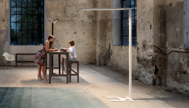 Une fille et un garçon debout à une table avec des luminaires.