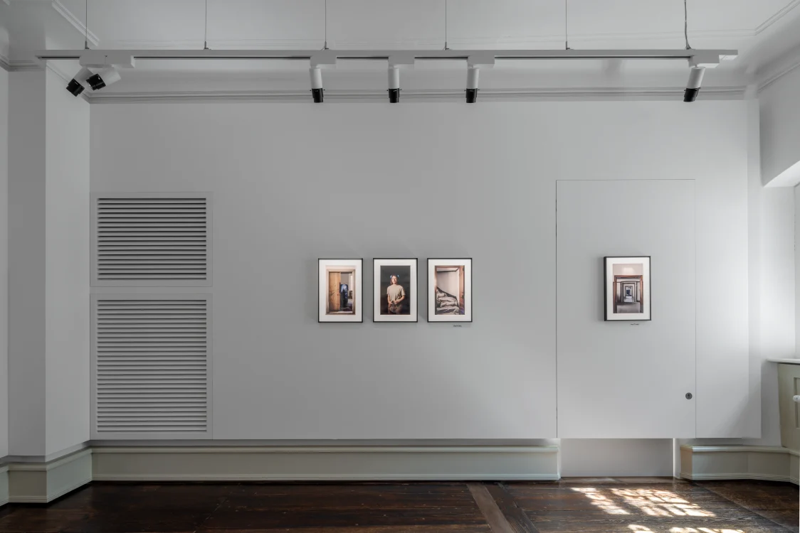 Minimalistischer Ausstellungsraum im Stadtmuseum Cavazzen in Lindau mit drei gerahmten Fotografien an der weißen Wand und moderner Lichtinstallation an der Decke.