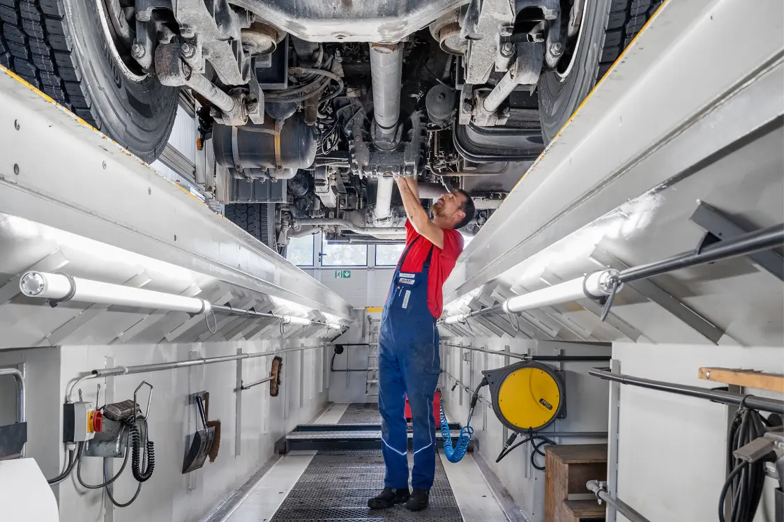 Mechaniker der Graf Nutzfahrzeuge AG während der Arbeit mit einem LKW auf der Hebebühne