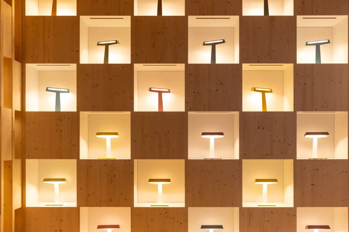 Image avec luminaire TALUNA sur un bureau avec un ordinateur portable et des étagères en arrière-plan
