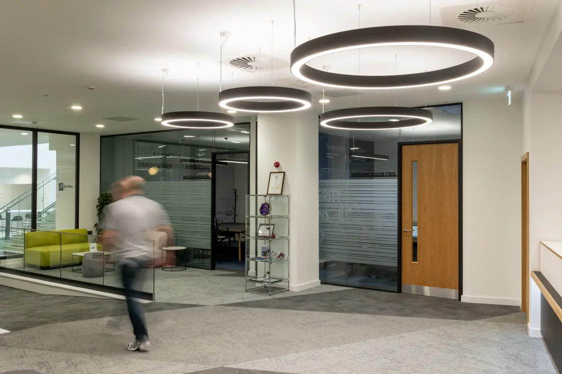 NG Bailey Headquarters, White Rose Office Park - A man walking through a modern circulation area