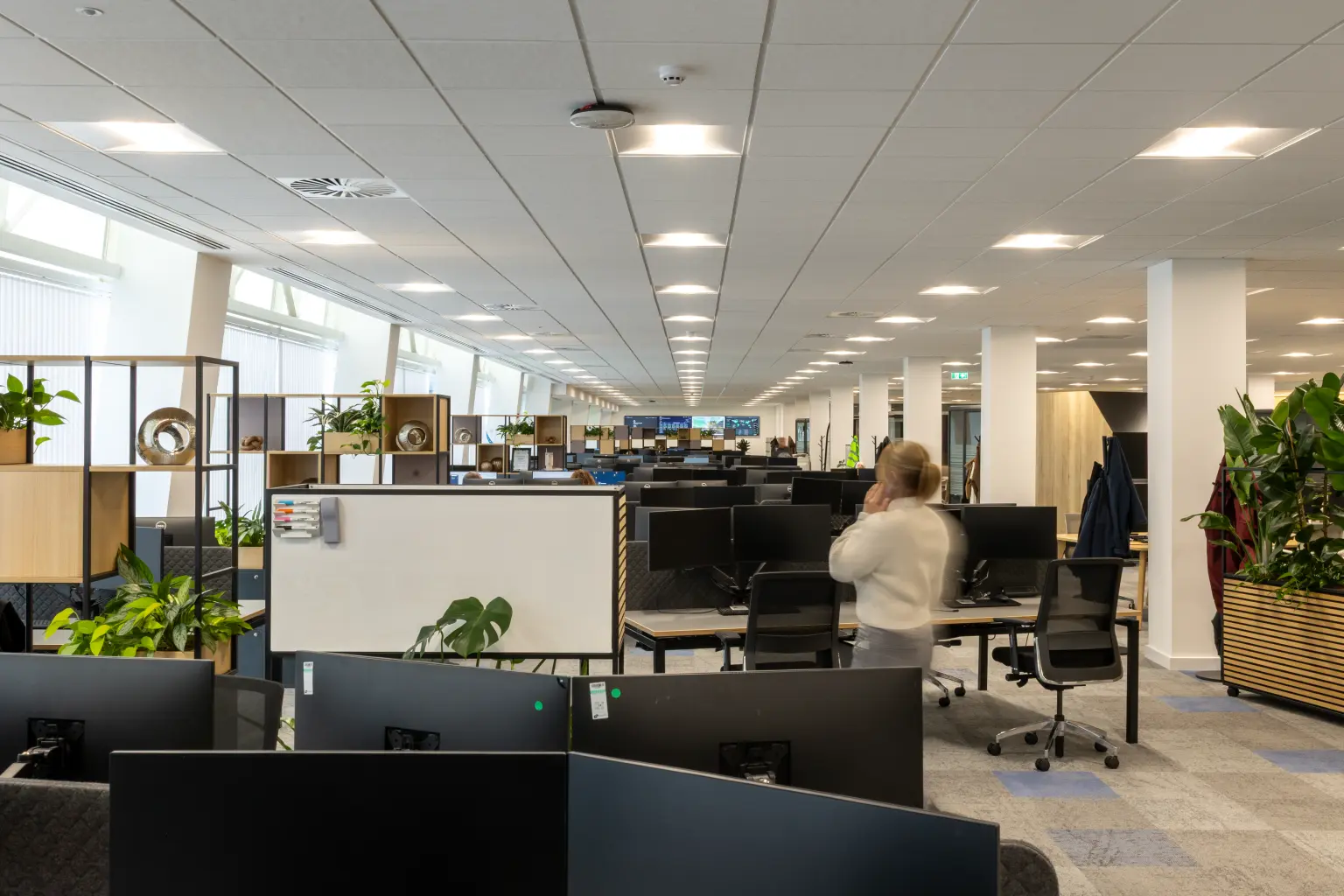 NG Bailey Headquarters, White Rose Office Park, Leeds - A lady on the phone in a modern and contemporary open plan office with desks, computers and seating