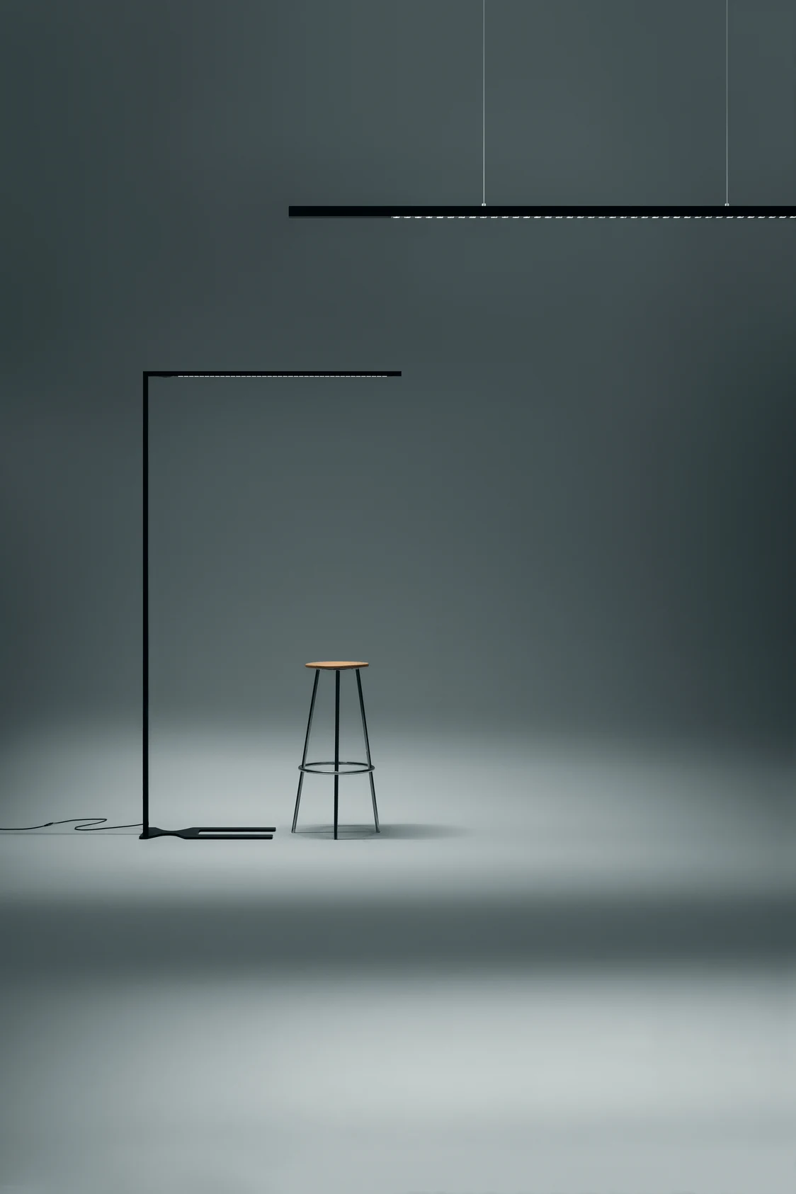 LINETIK Beleuchtungssystem in modernem Raum sorgt für gleichmäßiges Licht, ergänzt von minimalistischem Hocker unter Hängelampe, stilvoll inszeniert.