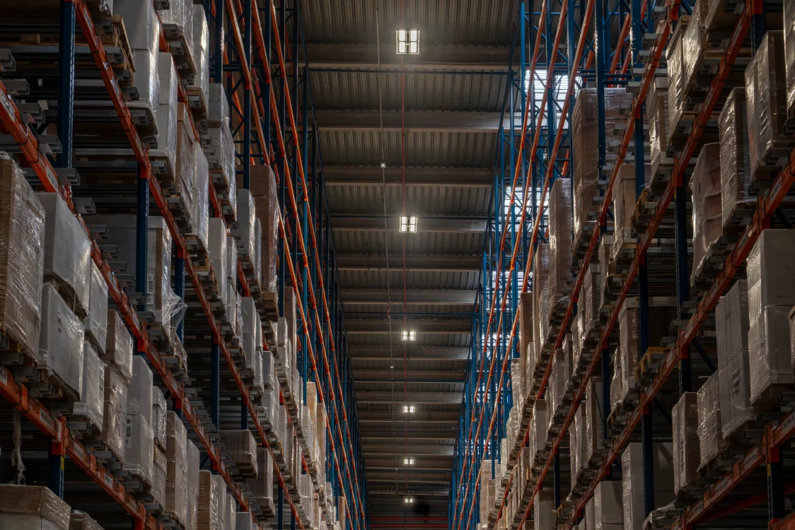 Warehouse racking aisle with pallet storage and high-efficiency LED lighting supporting safe and productive logistics operations.