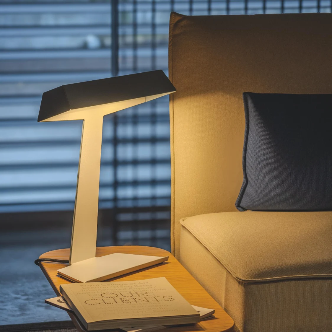 Taluna Table luminaire in yellow next to a couch. 