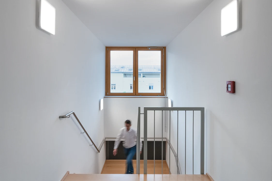 Scala in un condominio con finestra, illuminazione e una persona
