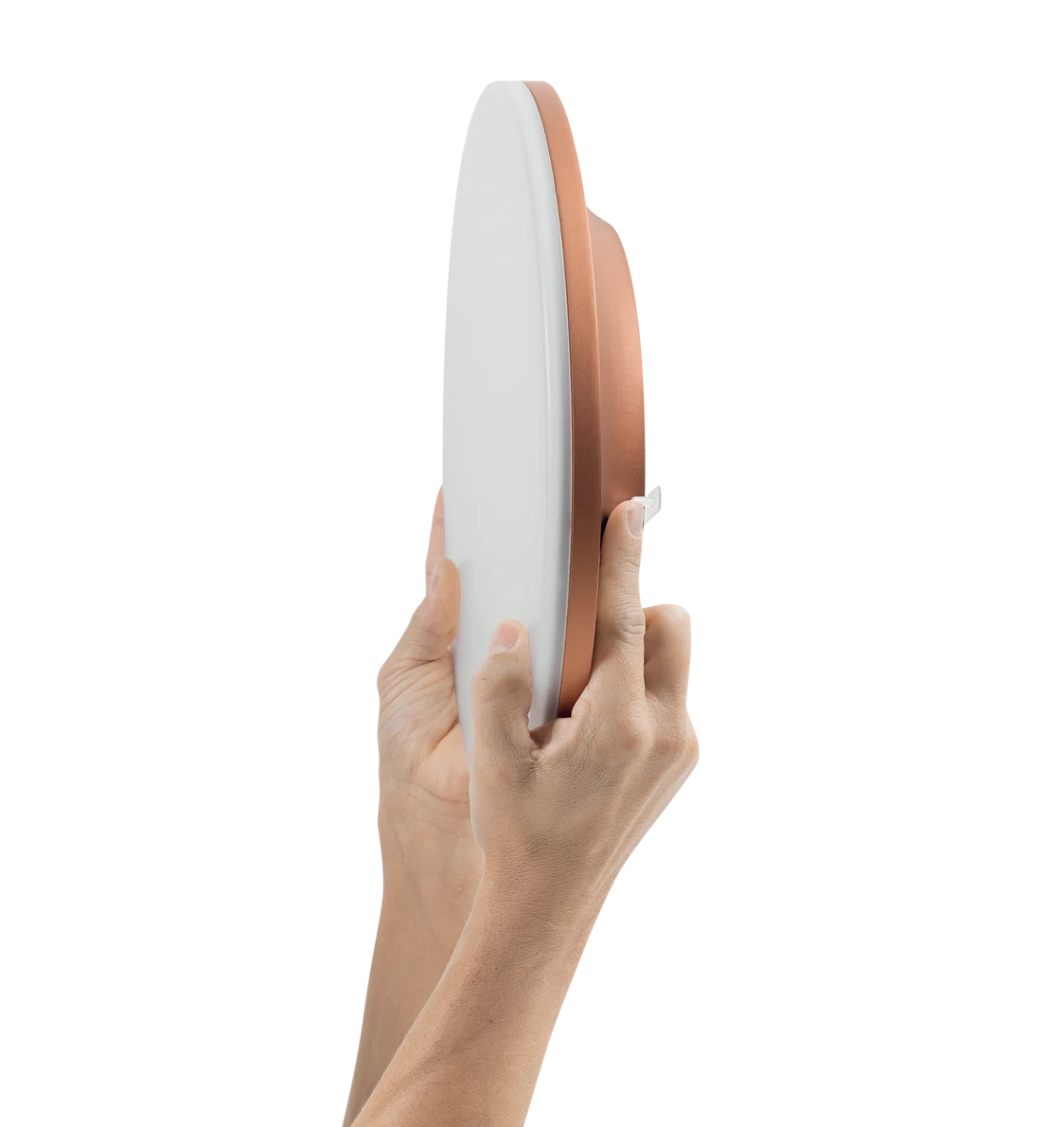 L'apparecchio illuminotecnico CAELA con elementi bianchi e color rame è presentato da due mani per sottolineare il suo design snello ed elegante.