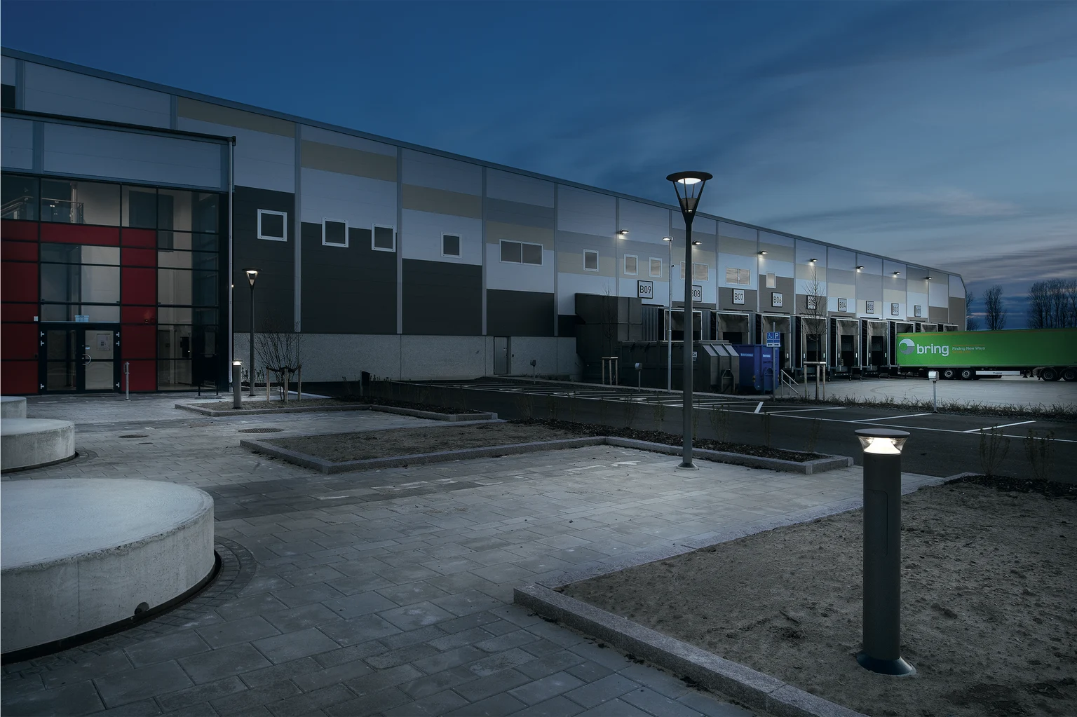 Das Logistikzentrum Boozt in Schweden wird nachts mit einem Mastaufsatz und einem Poller beleuchtet