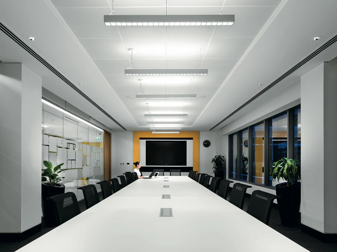 LINCOR lighting in a meeting room above a long white table.