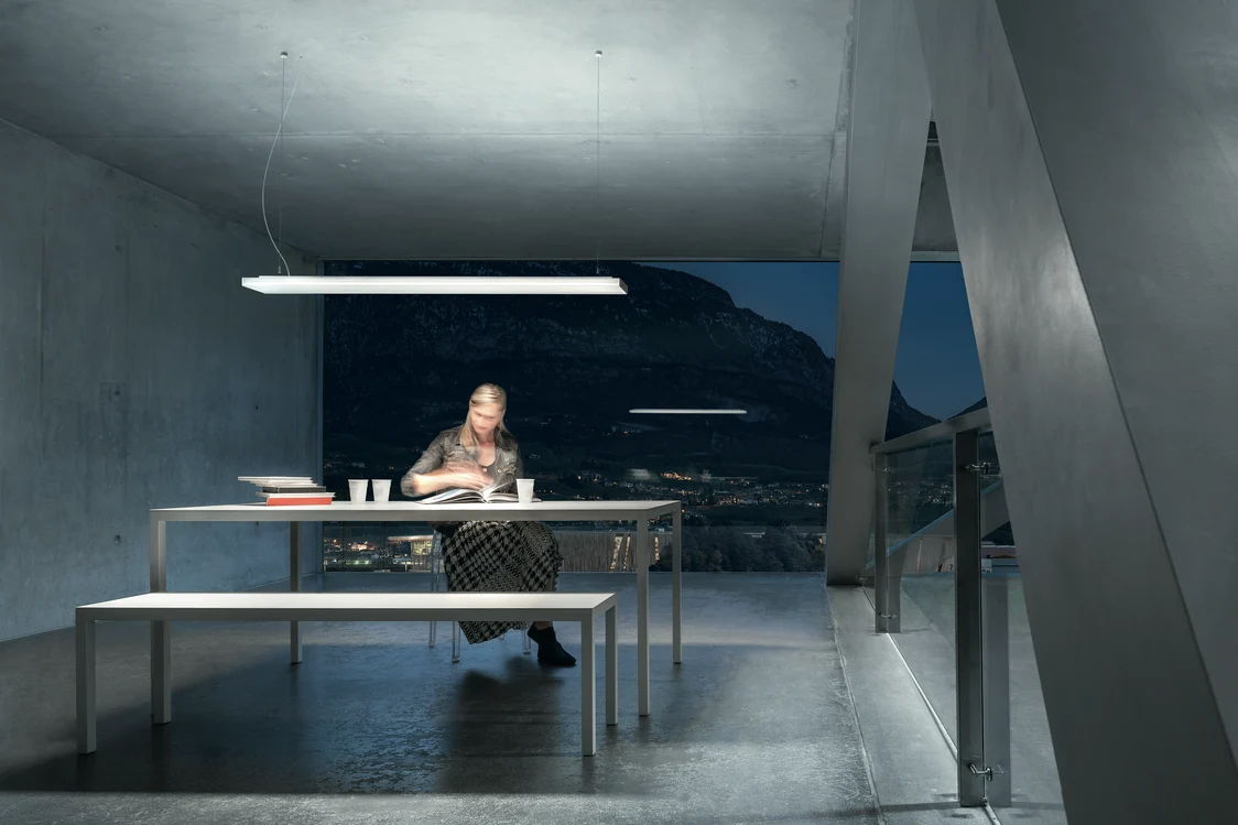 The ECOOS LED pendant lamp illuminates a modern office space with glare-free, bright white light and a minimalist design.