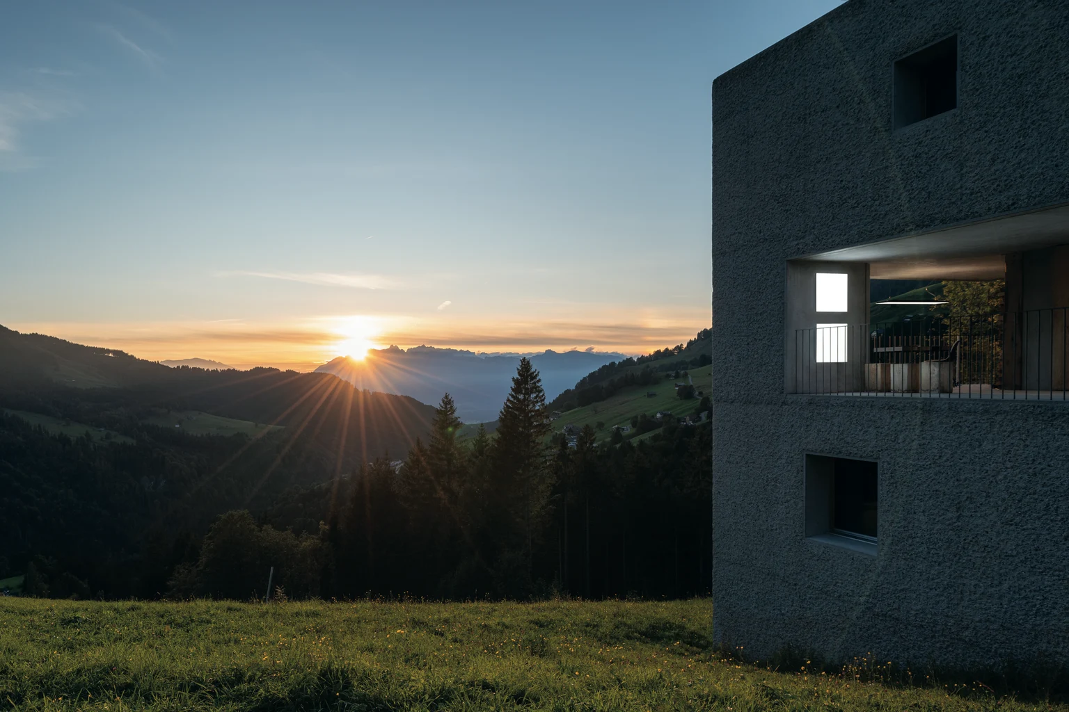 Coucher de soleil sur les Alpes avec un bâtiment moderne au premier plan, Zumtobel