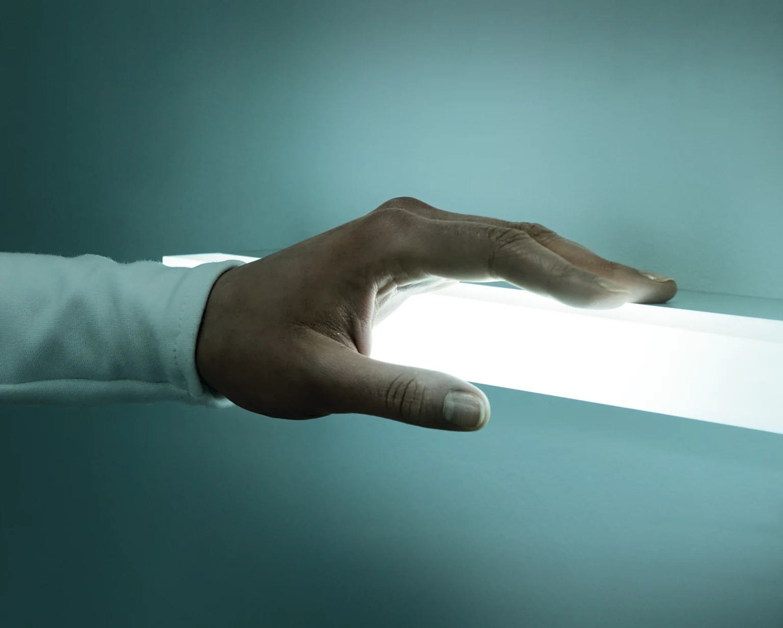 Een hand die een lichtlijn aanraakt. 