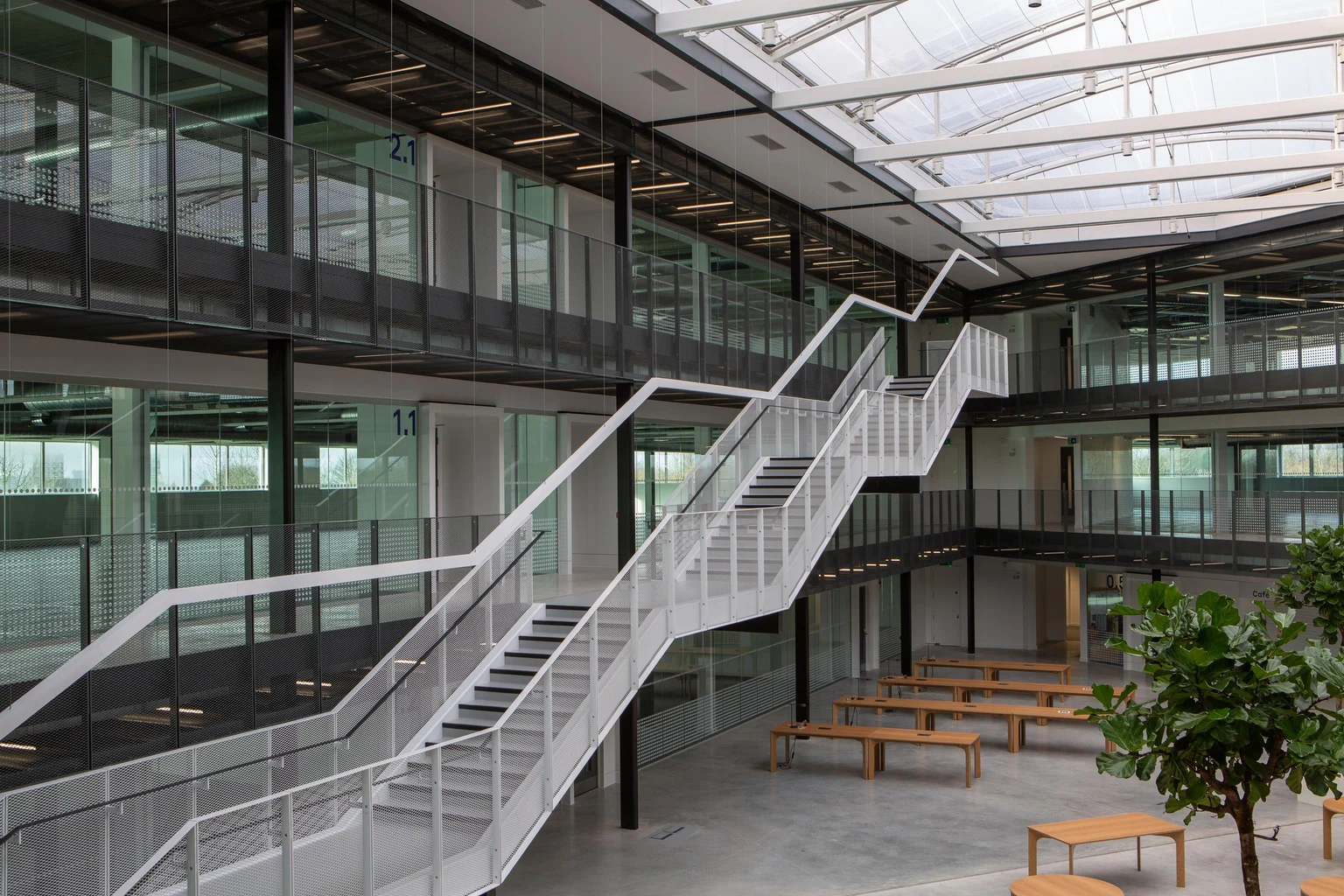 POPPACK in zwart onder rasterverlichting die de wandelgang van een commerciële kantoorruimte verlicht