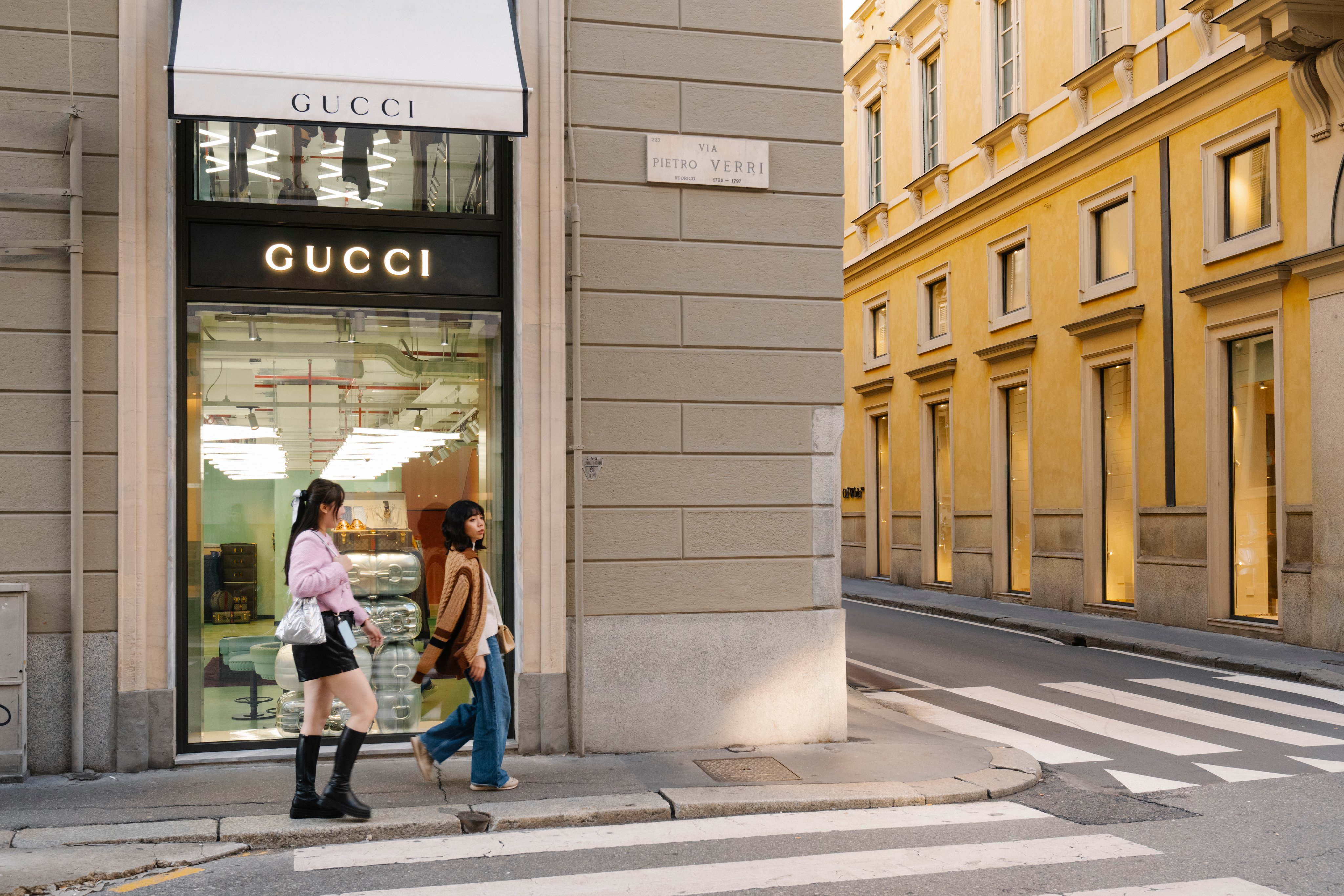 Gucci-Geschäft an einer Strassenecke. Zwei Frauen laufen daran vorbei.