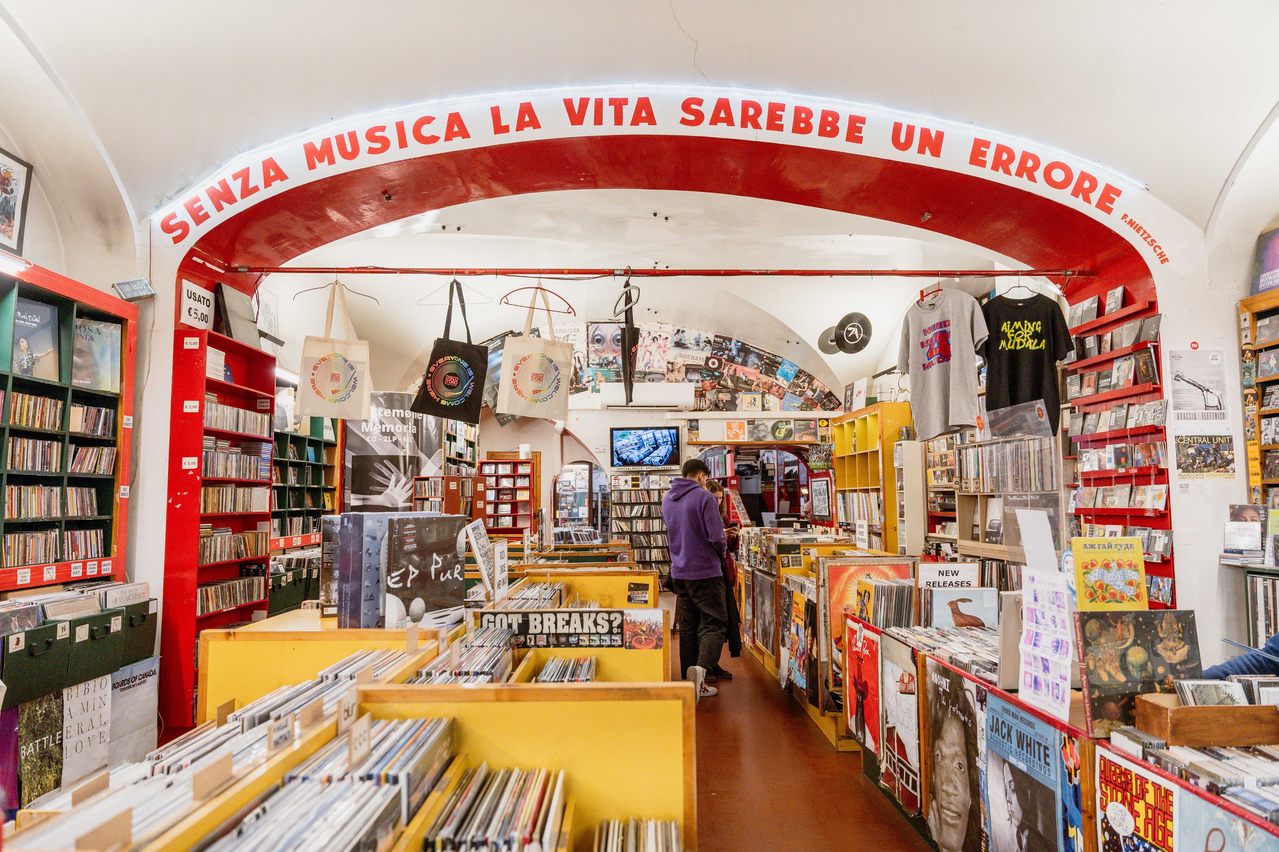 Plattenladen mit Vinyl, CDs und Musikpostern unter gewölbter Decke.