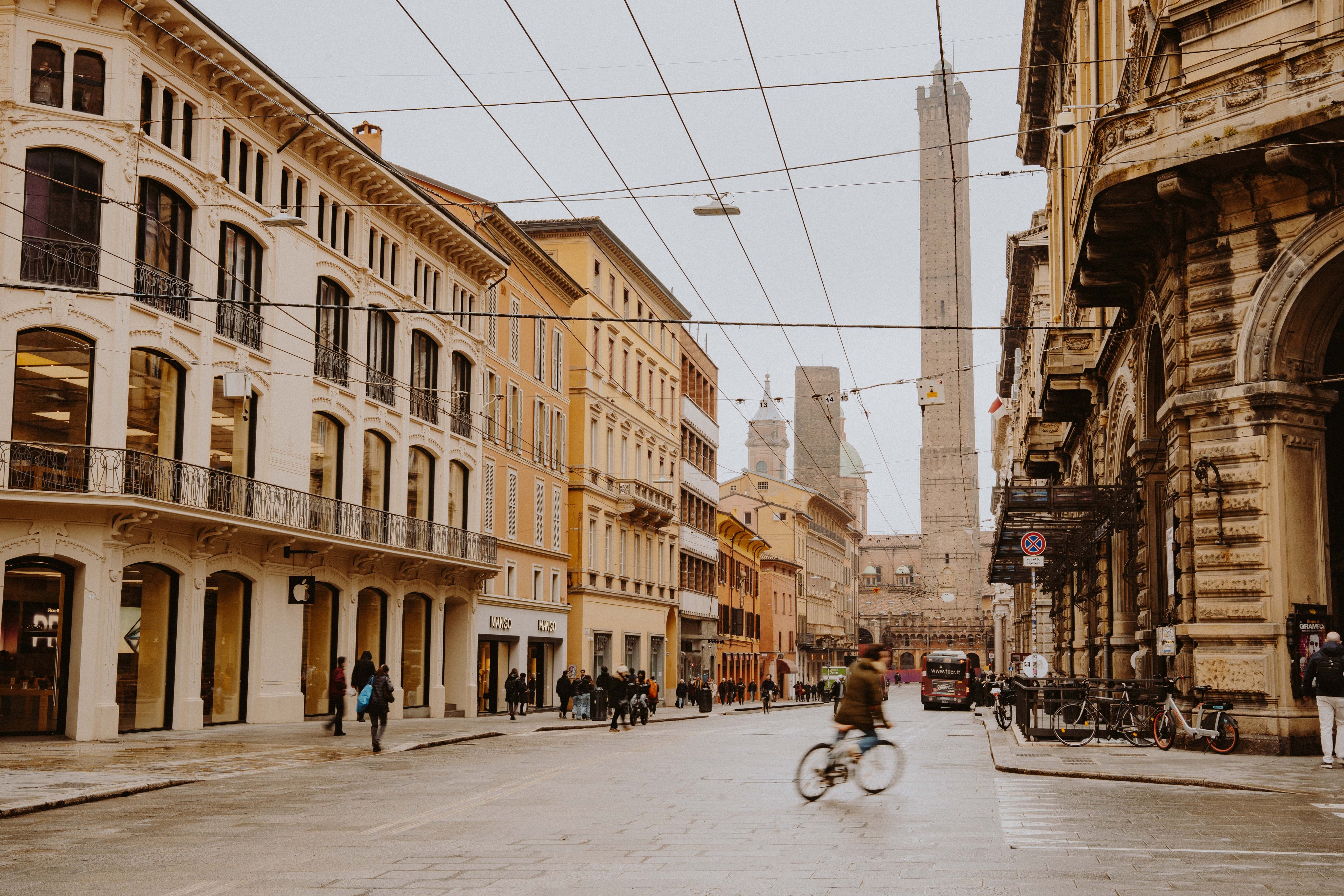 Belebte Strasse in Bologna mit Gebäuden und Asinelli-Turm