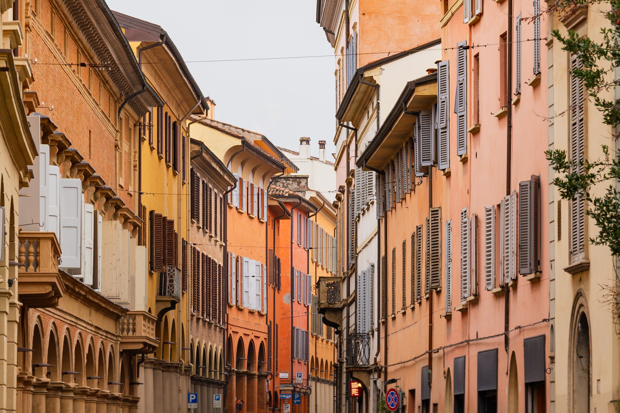 Schmale Gasse mit bunten Fassaden und hölzernen Fensterläden