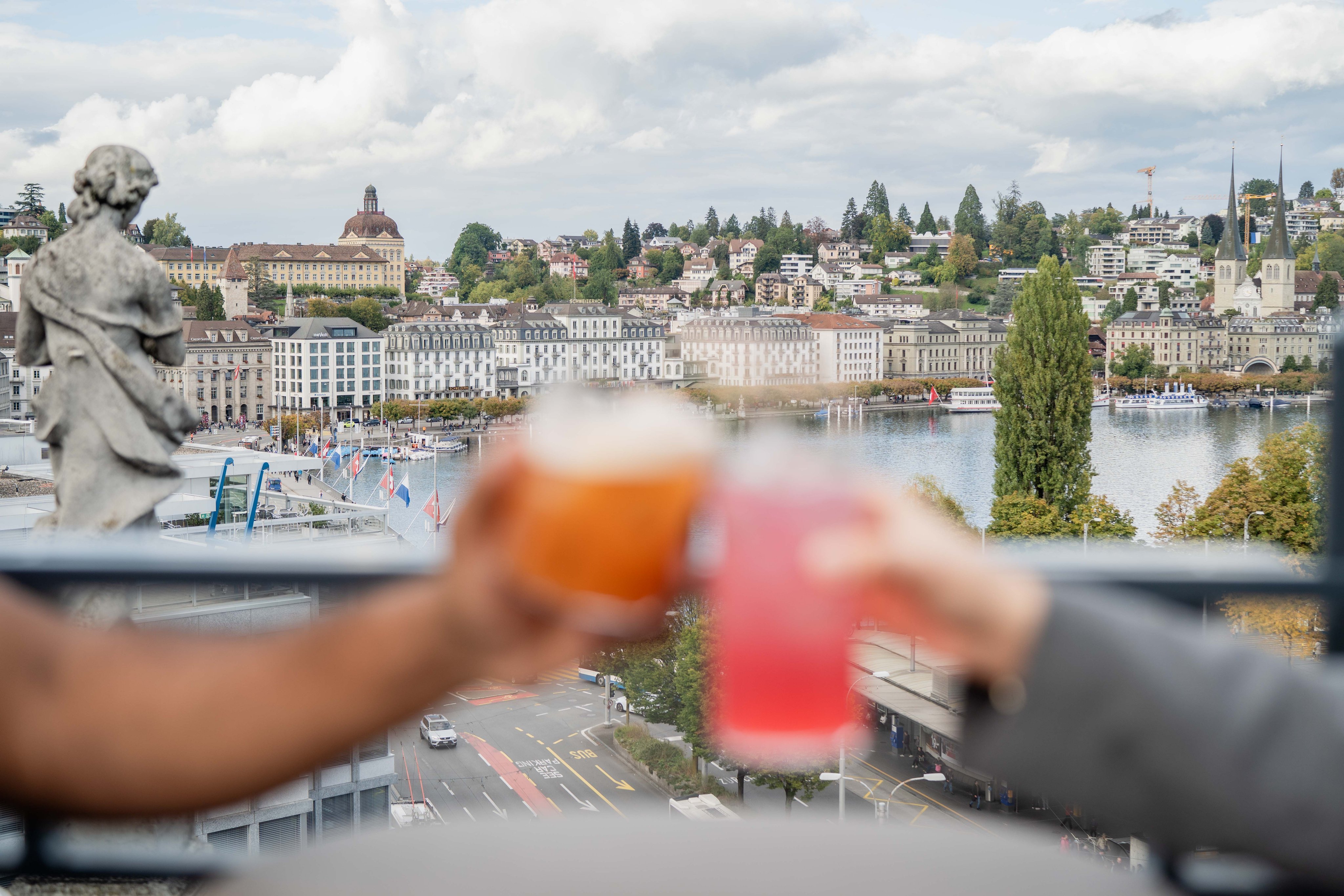 View of the city of Lucerne. Two cocktail glasses toasting in the foreground.