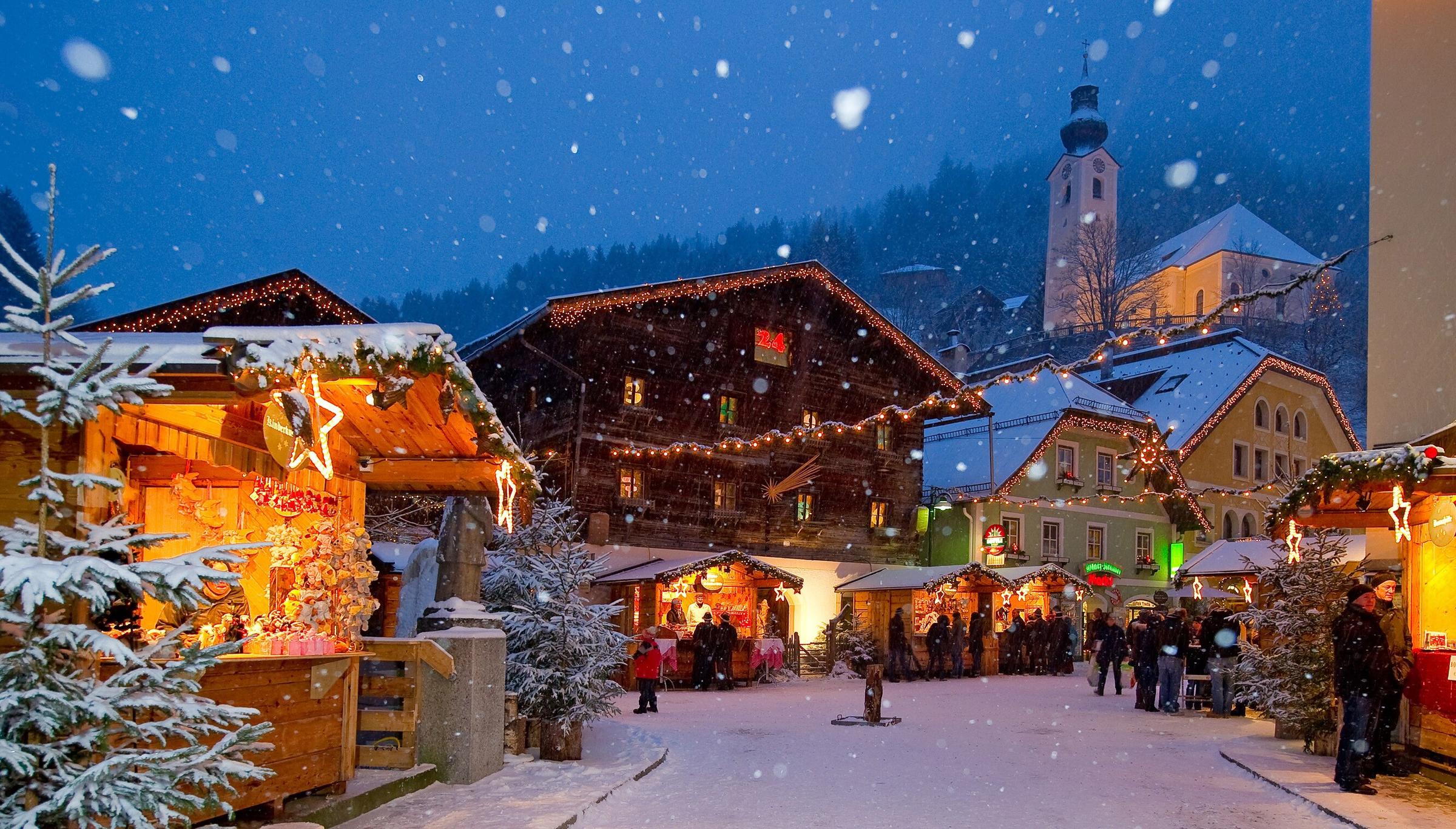 Verschneite Gasse mit Ständen am Salzburger Christkindlmarkt.