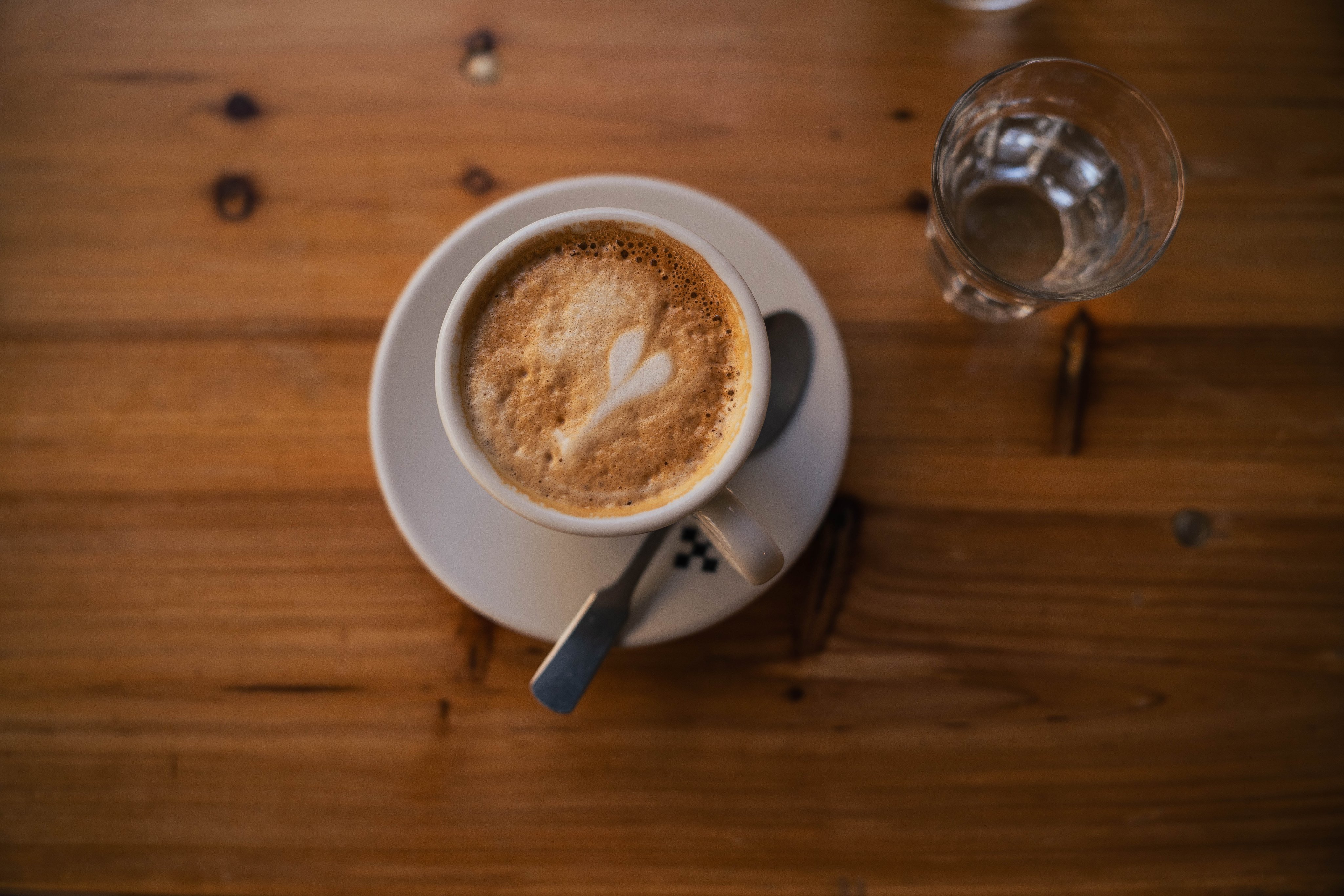 Eine Tasse Kaffee mit Milchschaum auf einem Holztisch.