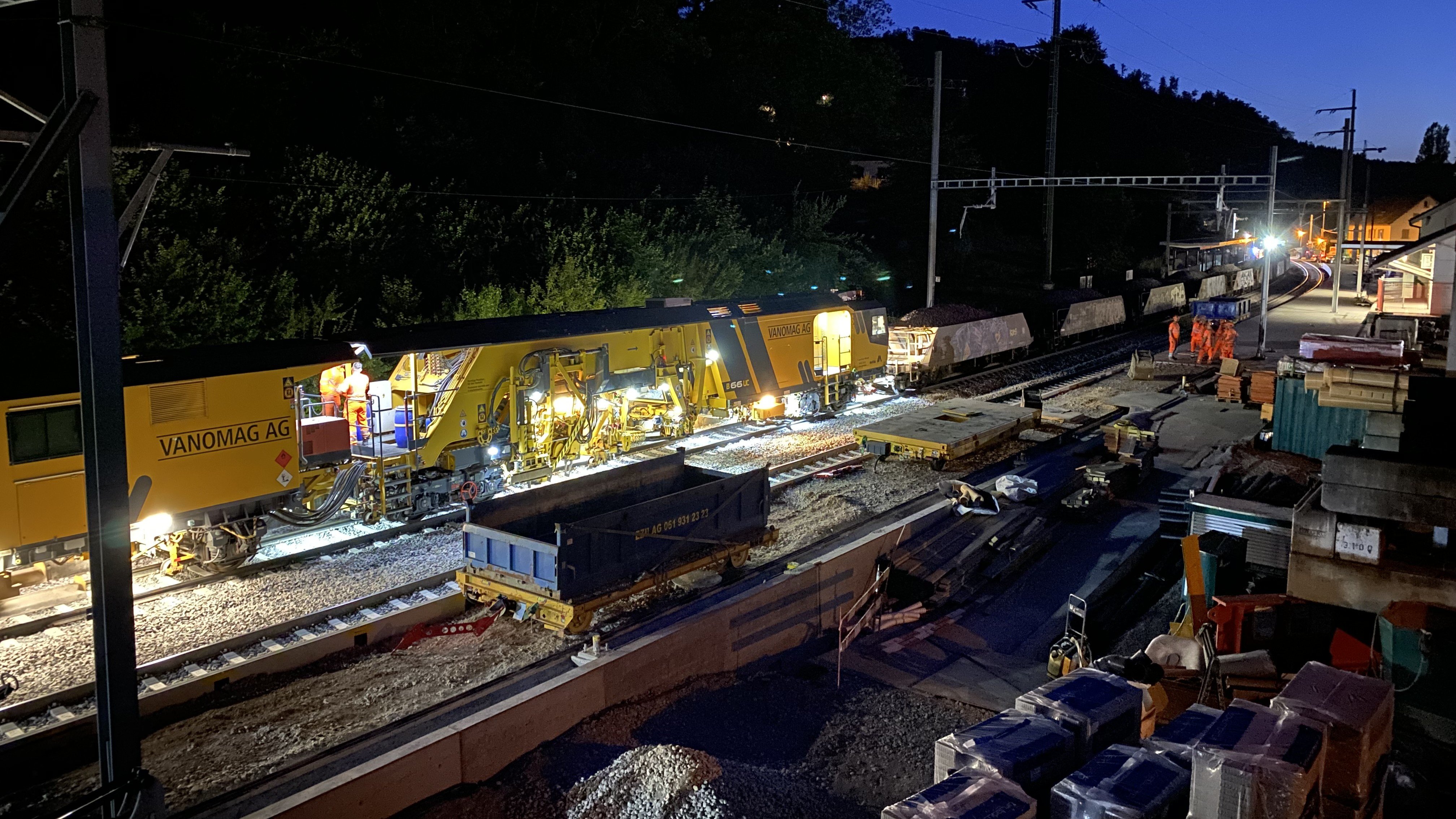 Eine Schotterstopfmaschine bei Nachtarbeiten im Bahnhof Grellingen.